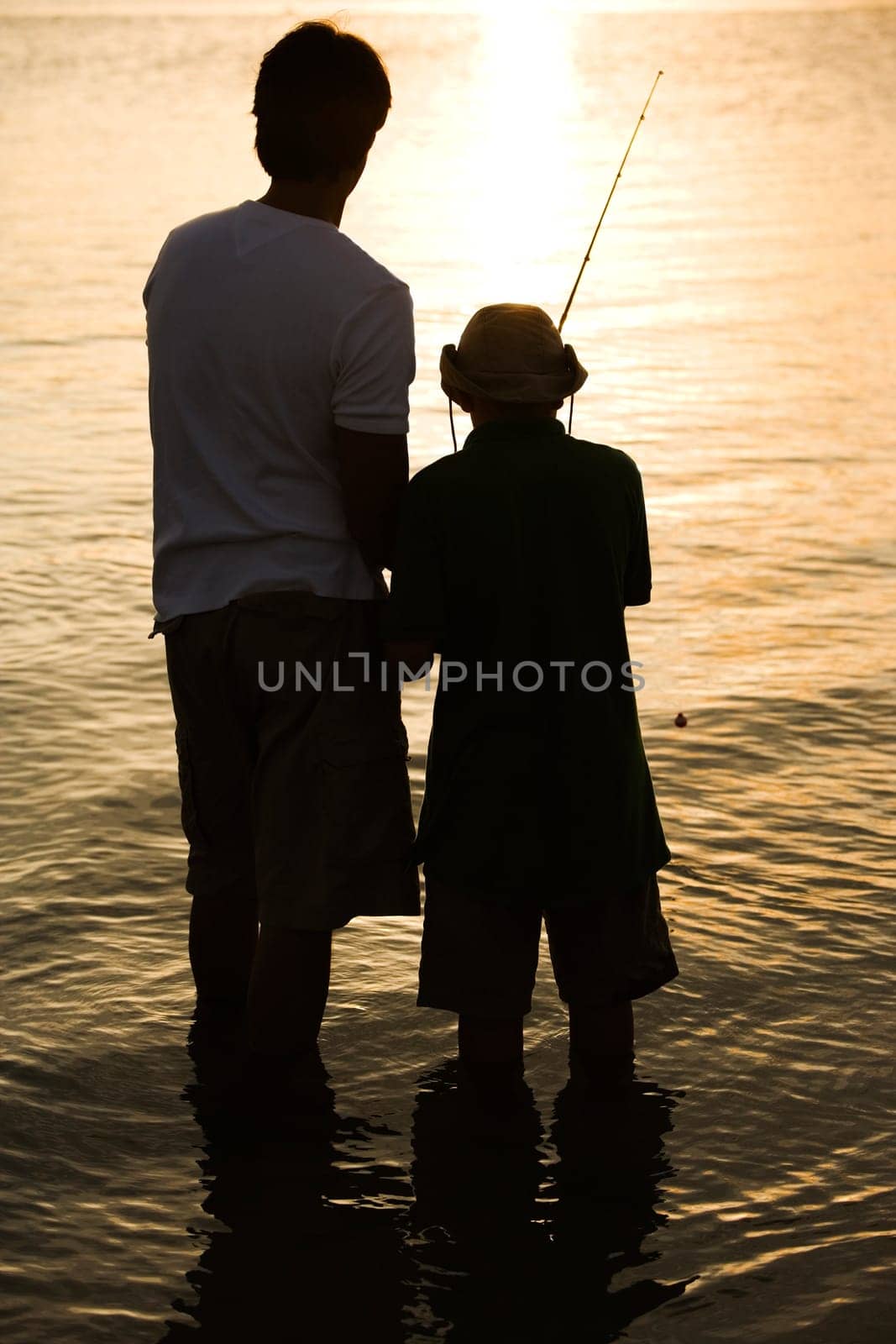 Silhouette of a father and his son fishing