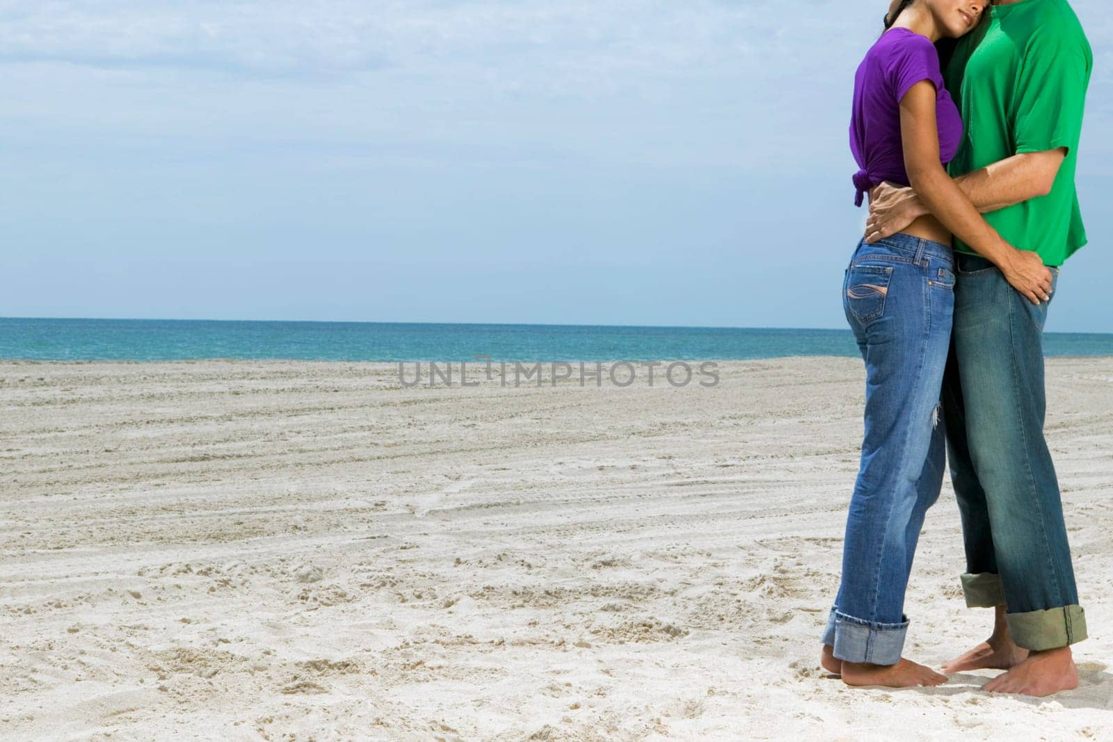 Side profile of a young couple embracing each other on the beach