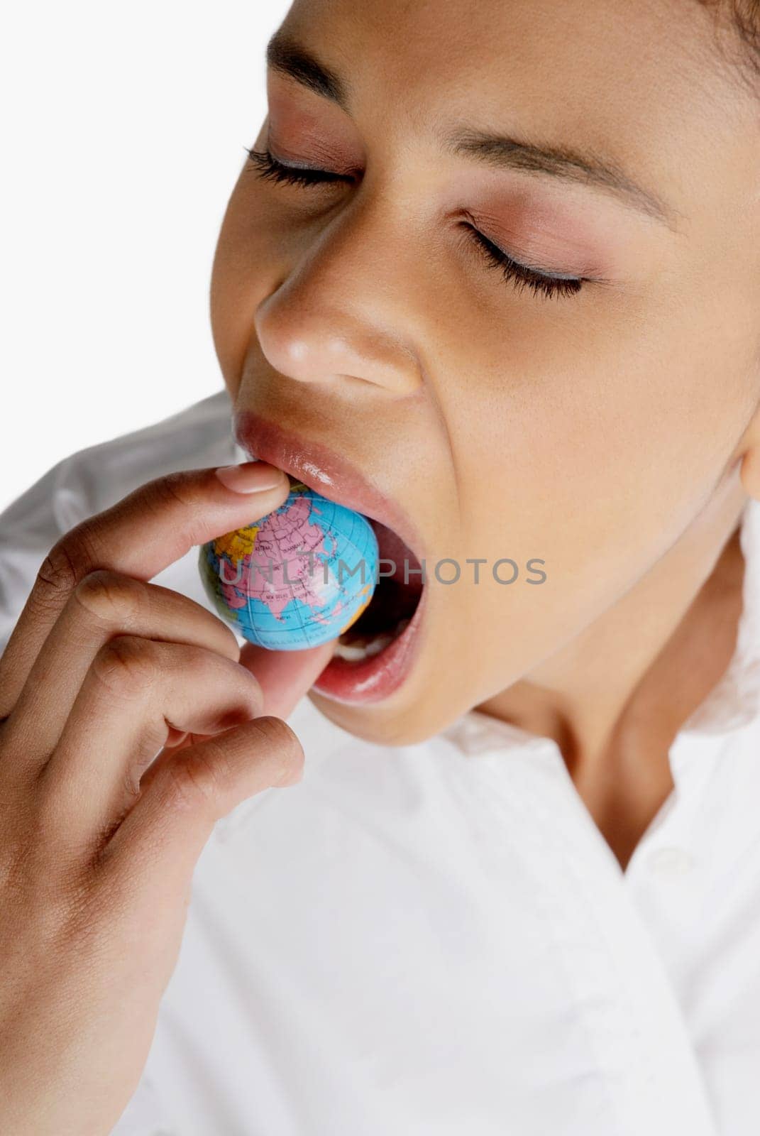 Close-up of a businesswoman holding a globe in her mouth
