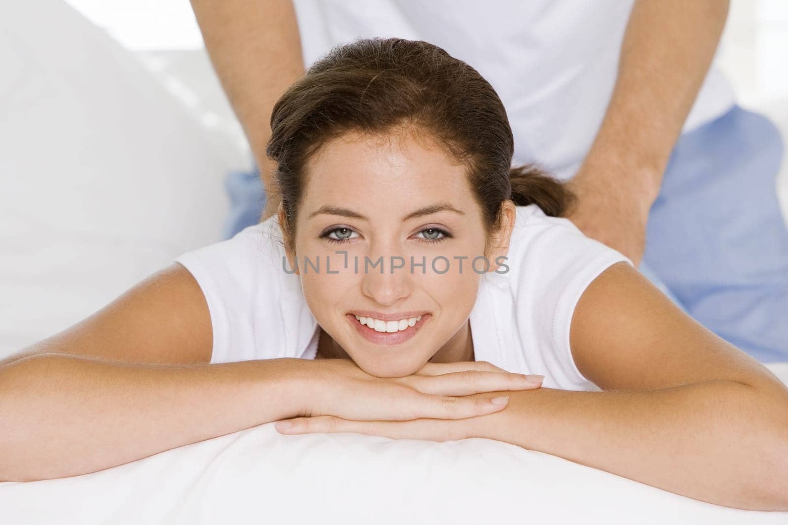 Portrait of a young woman getting a back massage from a young man
