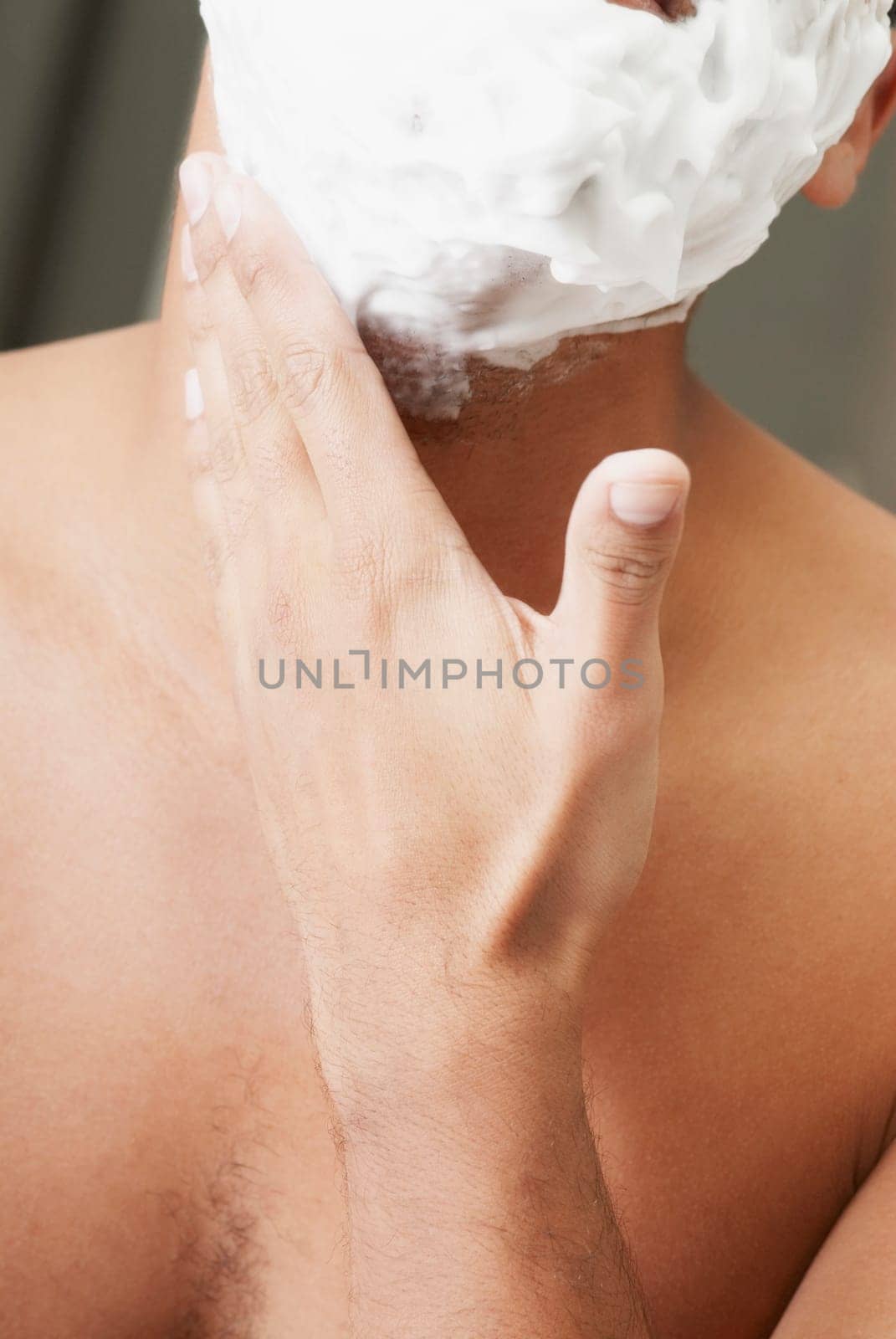 Close-up of a young man applying shaving cream on his face