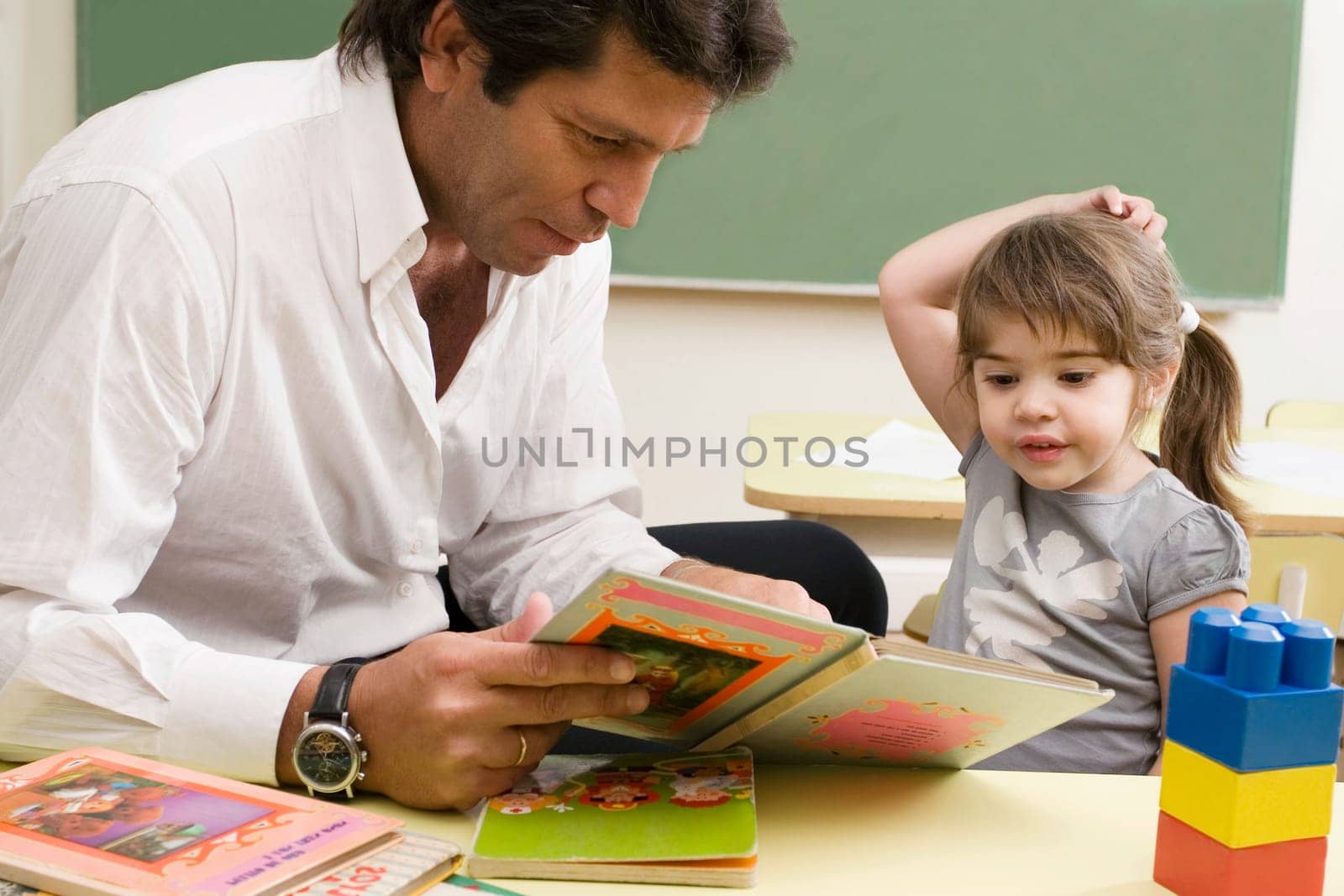 Male teacher teaching his student in a classroom