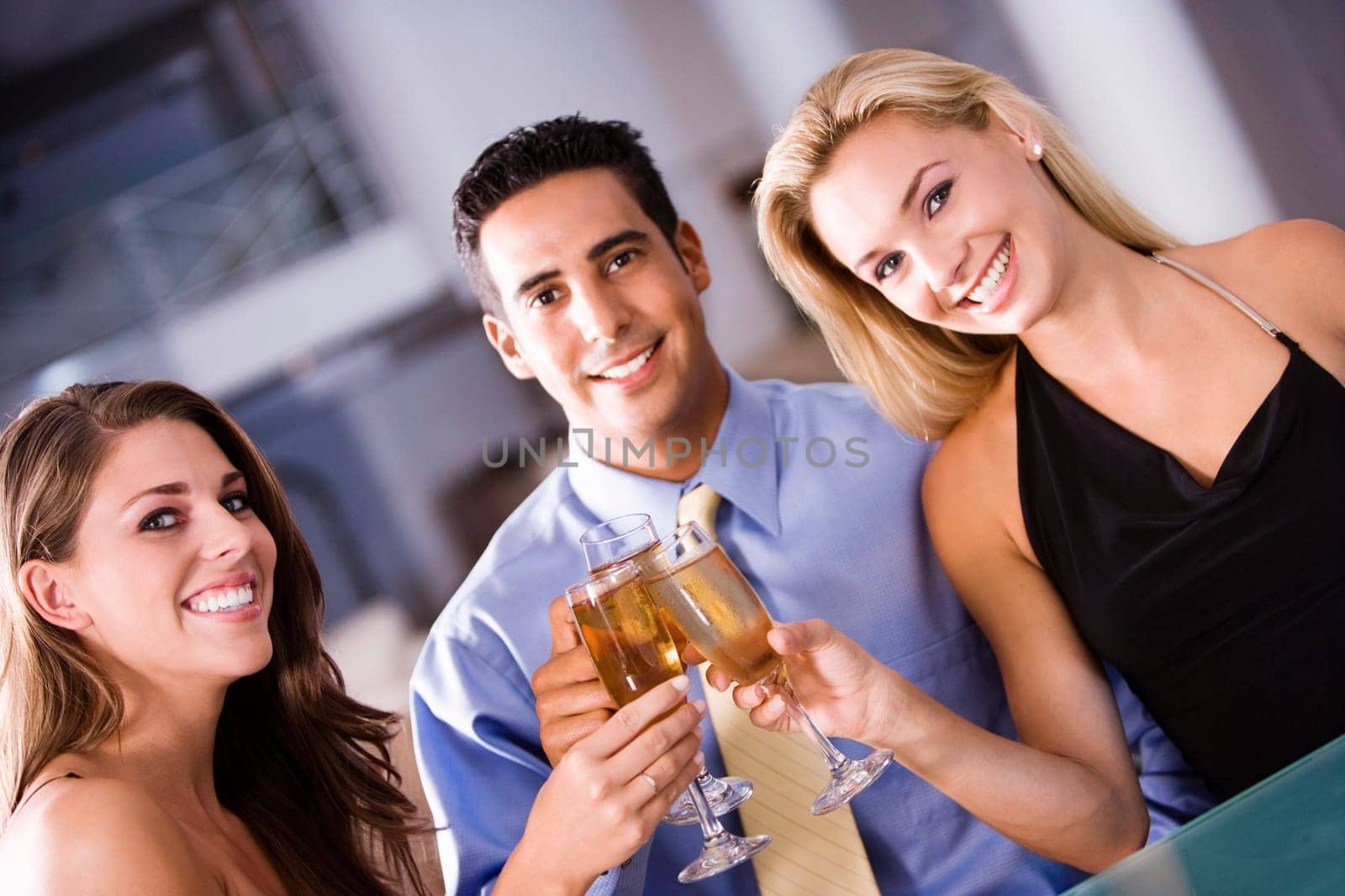 Portrait of a mid adult man and two young women raising a toast