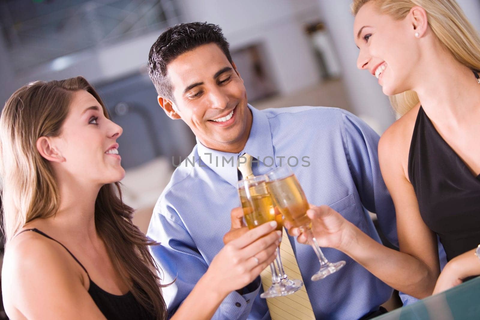 Two young women and a mid adult man toasting