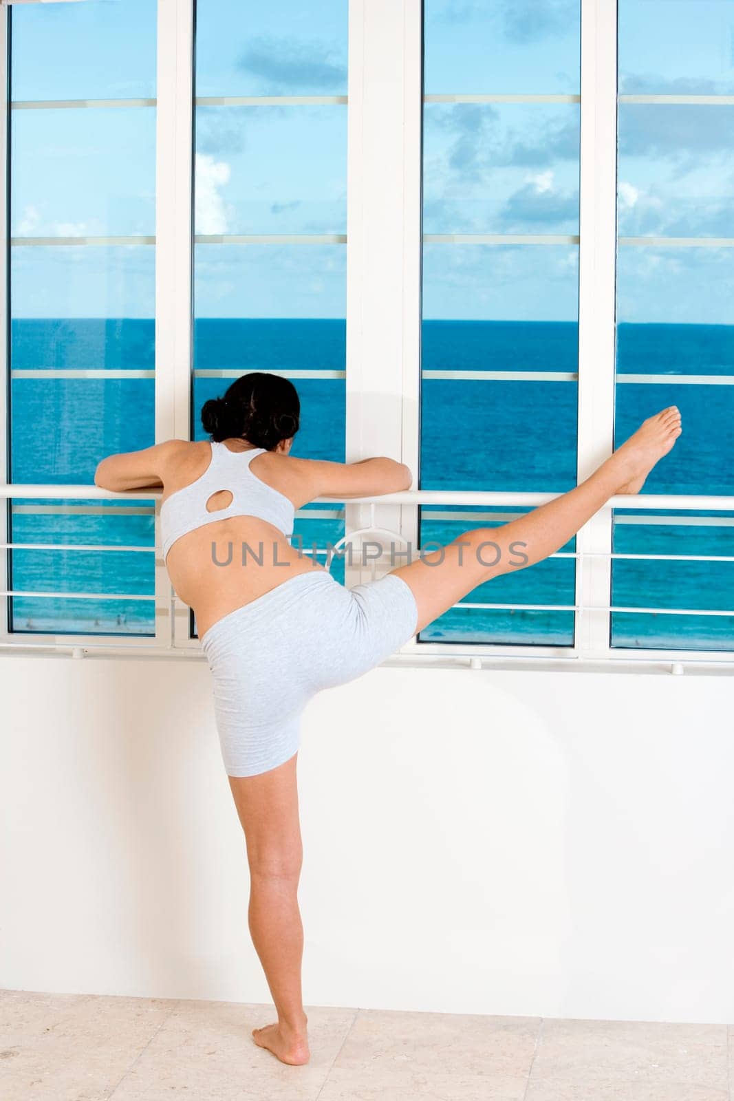 Rear view of a young woman stretching her legs