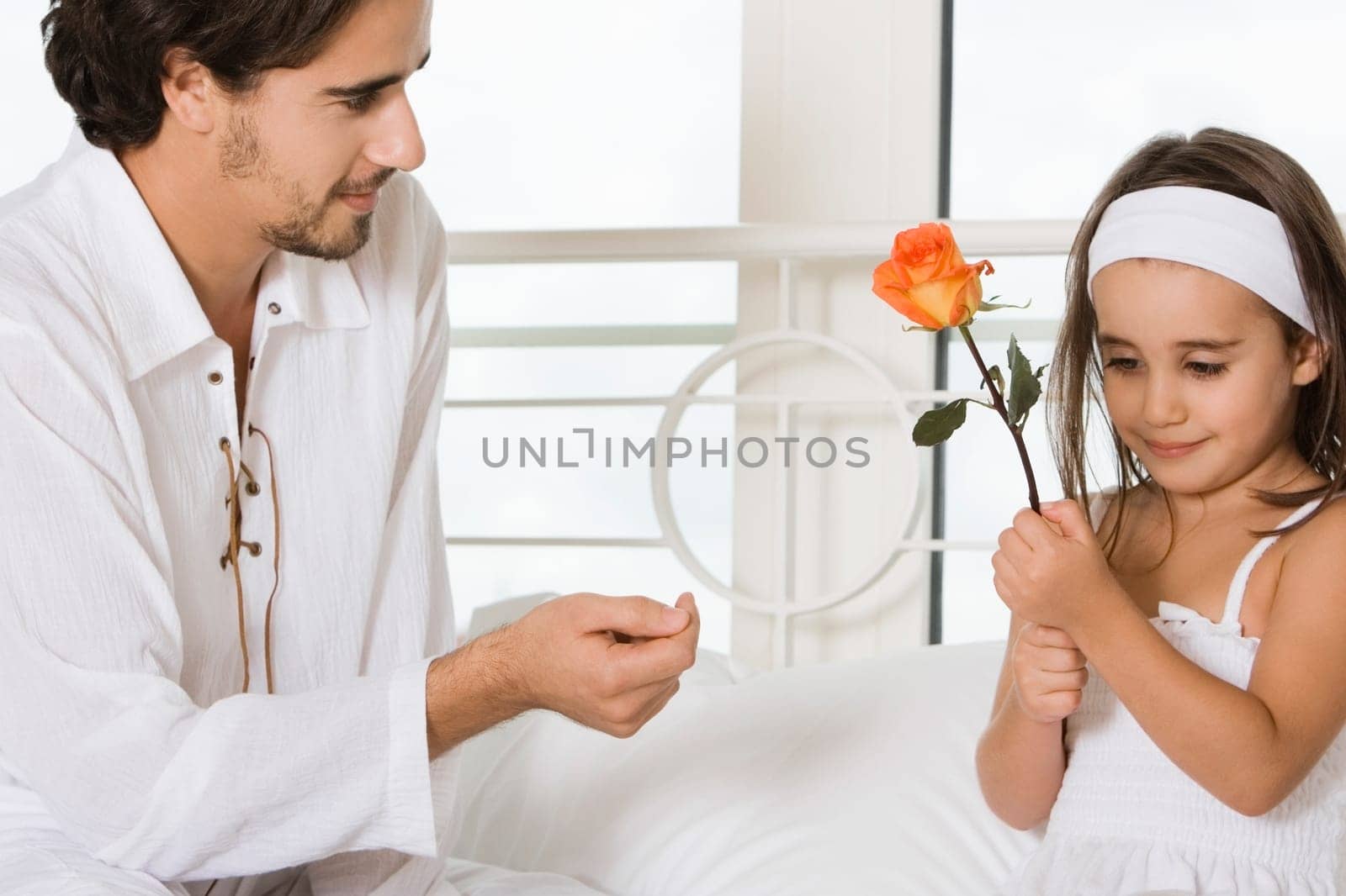 Close-up of a young man looking at his daughter holding a flower