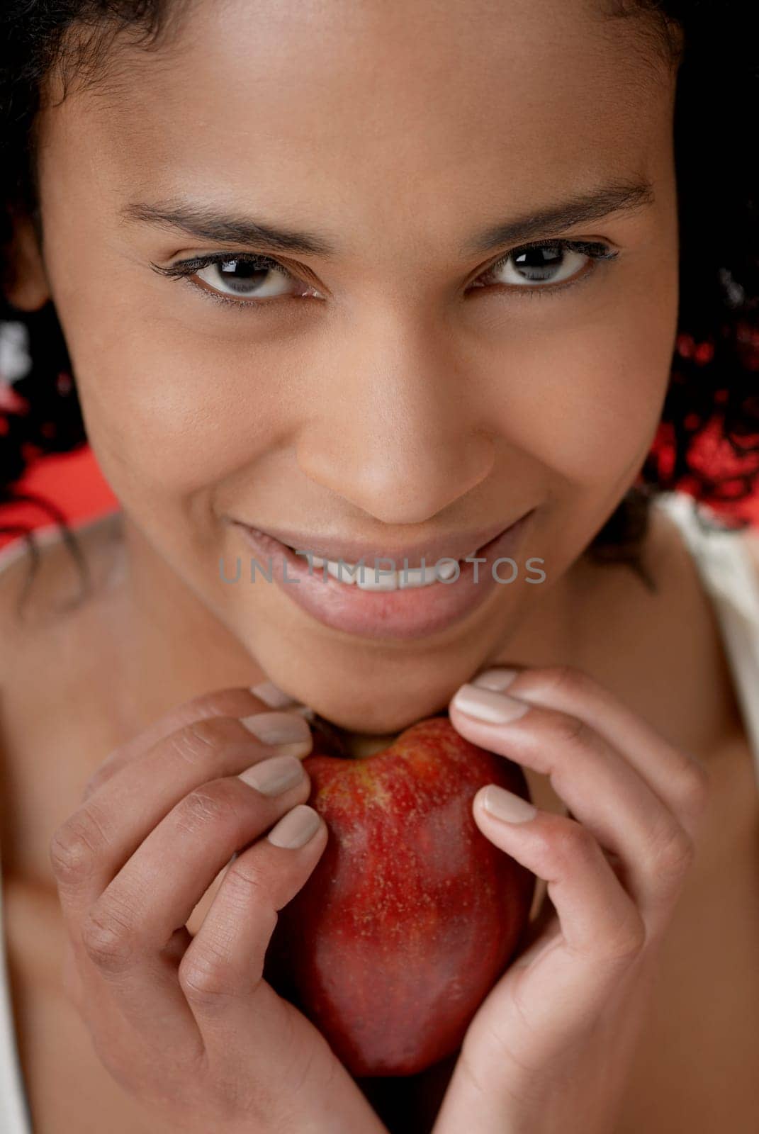 Portrait of a young woman holding an apple under her chin