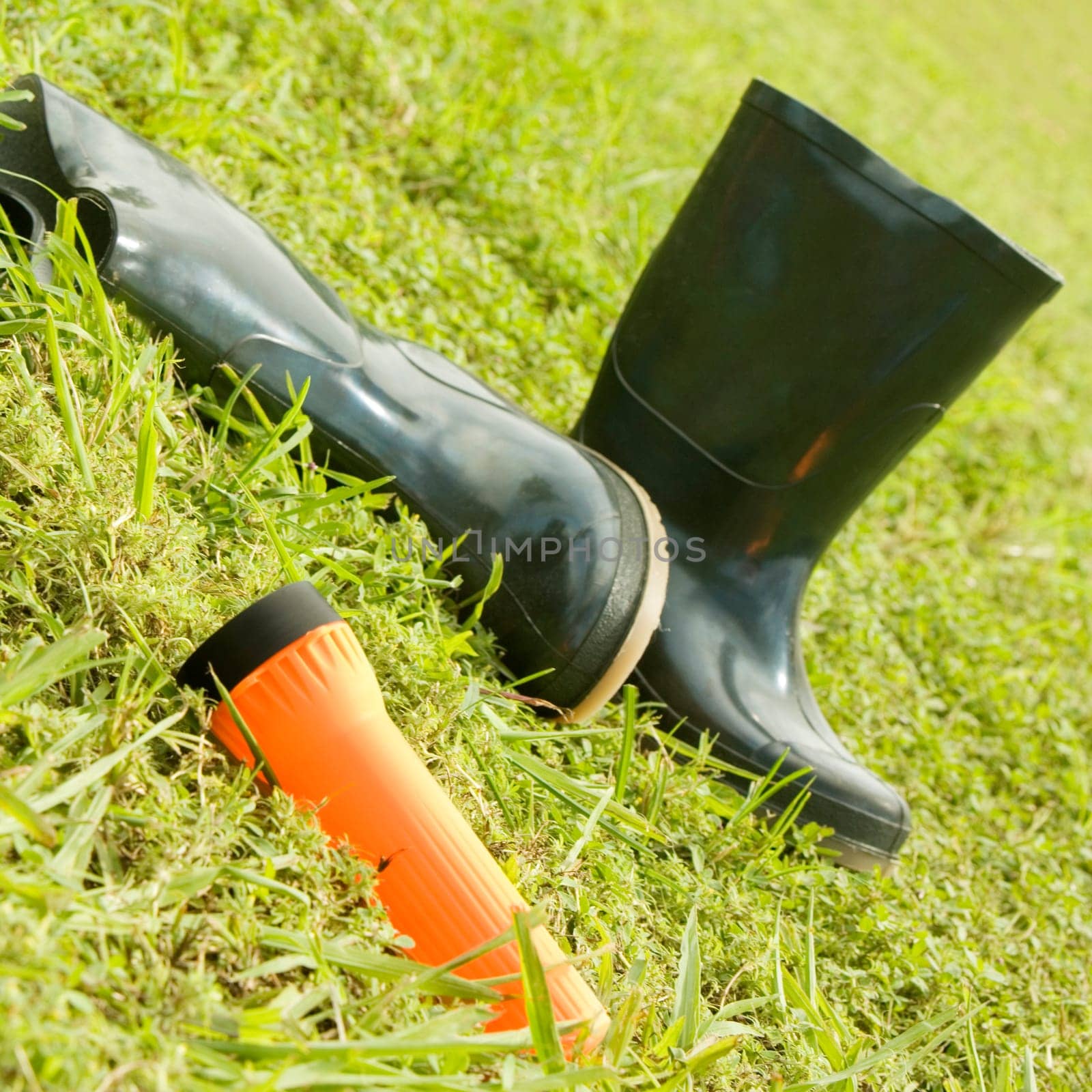 Close-up of a pair of boots with a flashlight on the grass