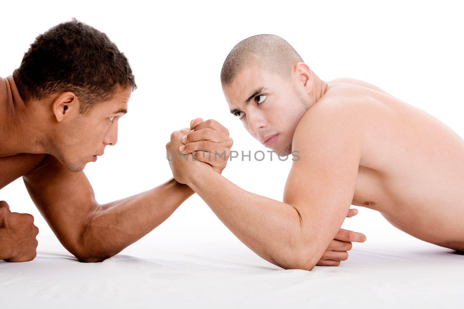 Side profile of two young men arm wrestling