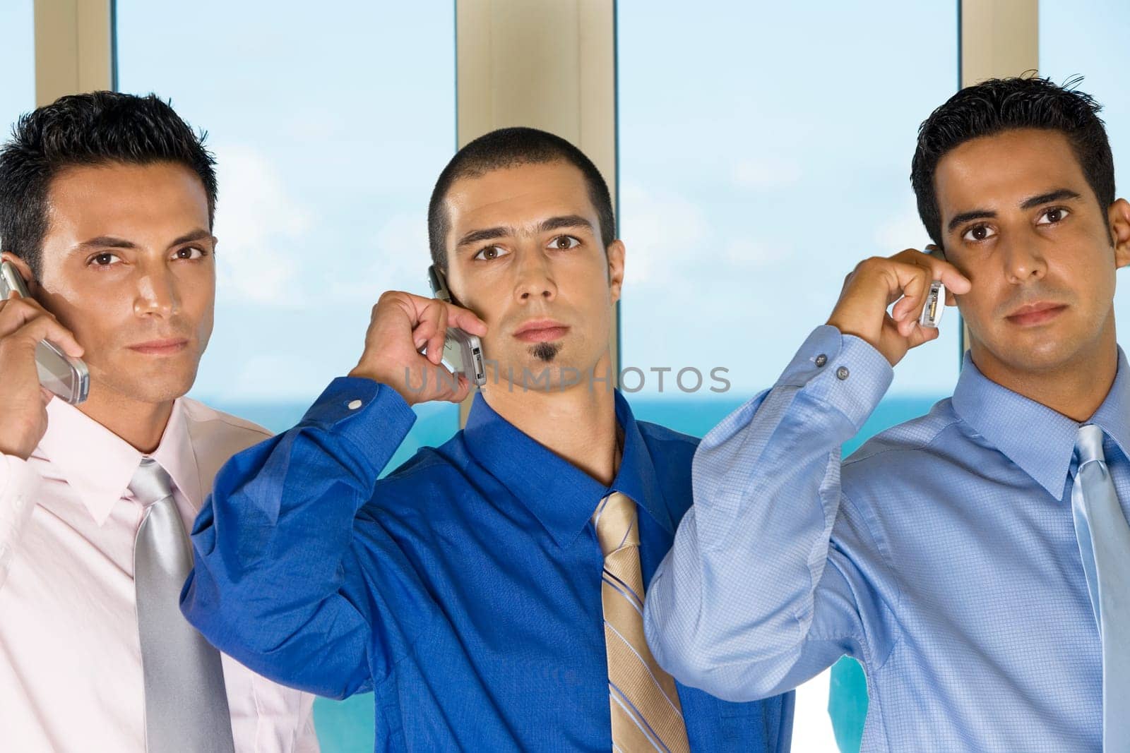 Portrait of three businessmen talking on mobile phones