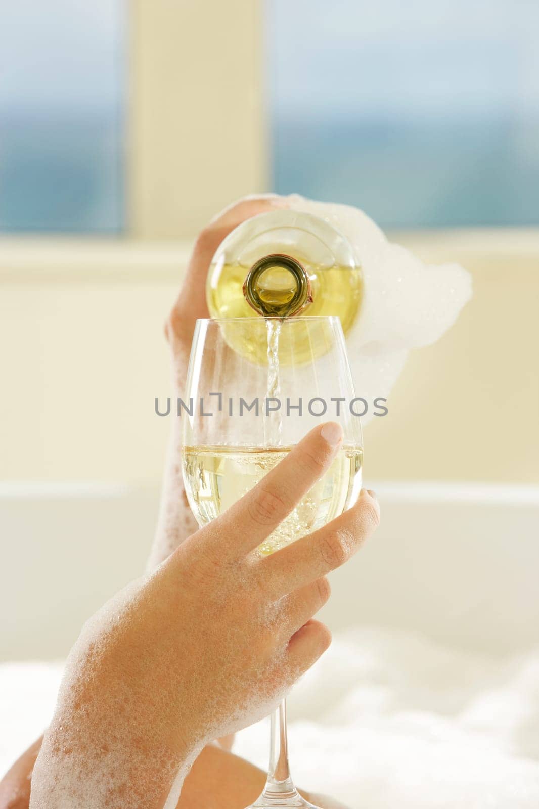 Close-up of a womanŽs hand pouring champagne in champagne flute