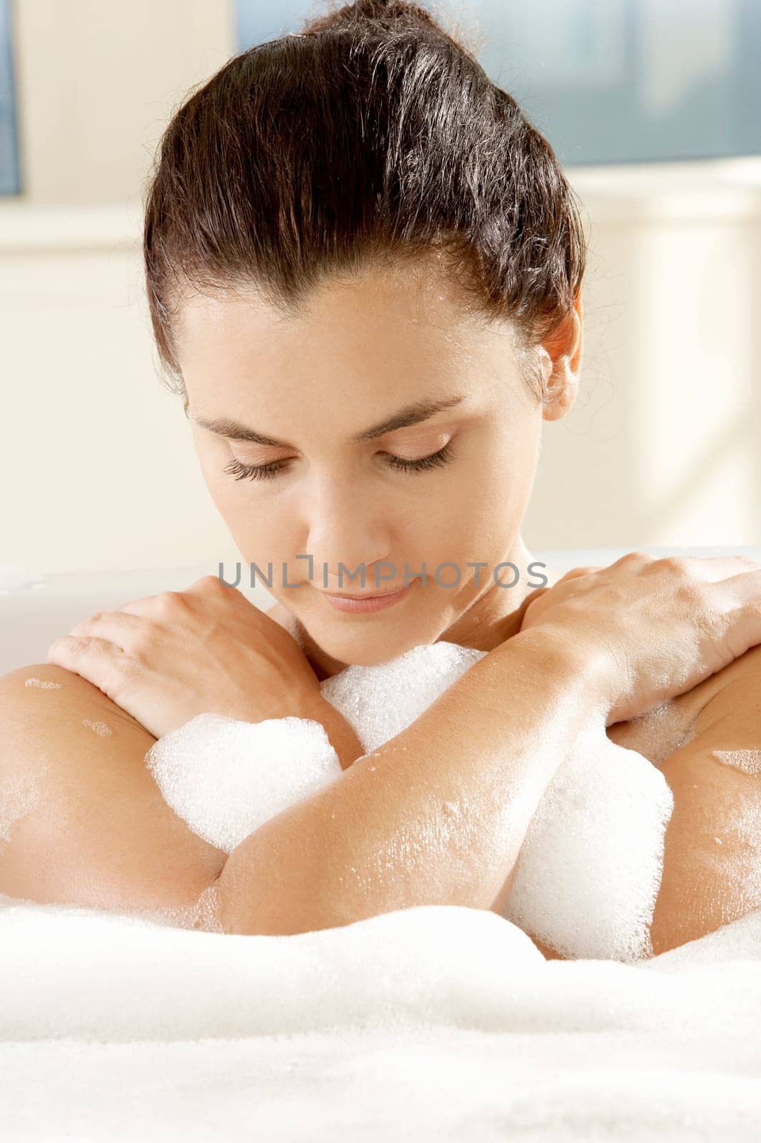 Close-up of a young woman with her eyes closed in a bathtub