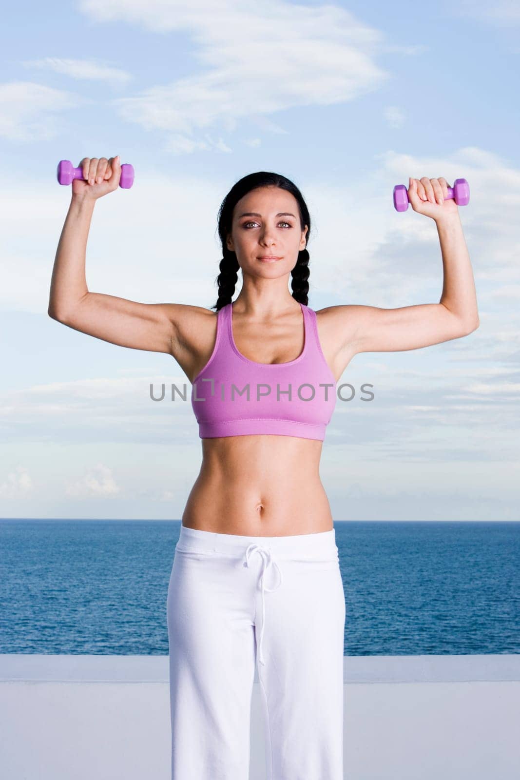 Portrait of a young woman exercising with dumbbells
