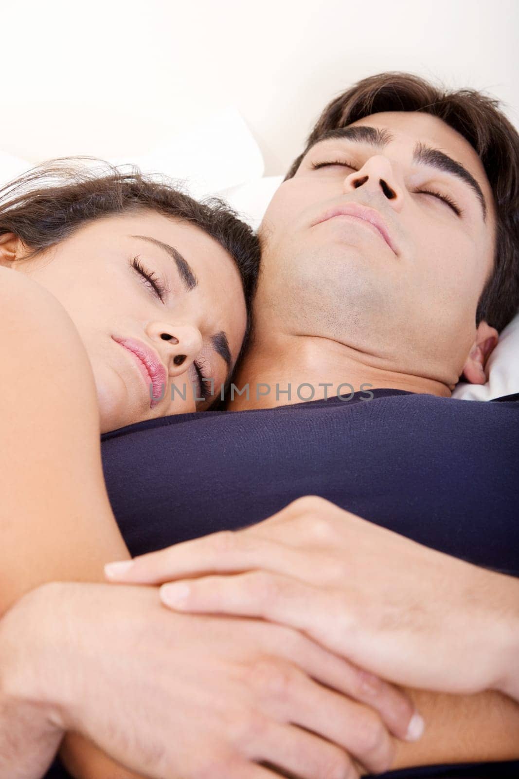 Close-up of a young couple sleeping on a bed