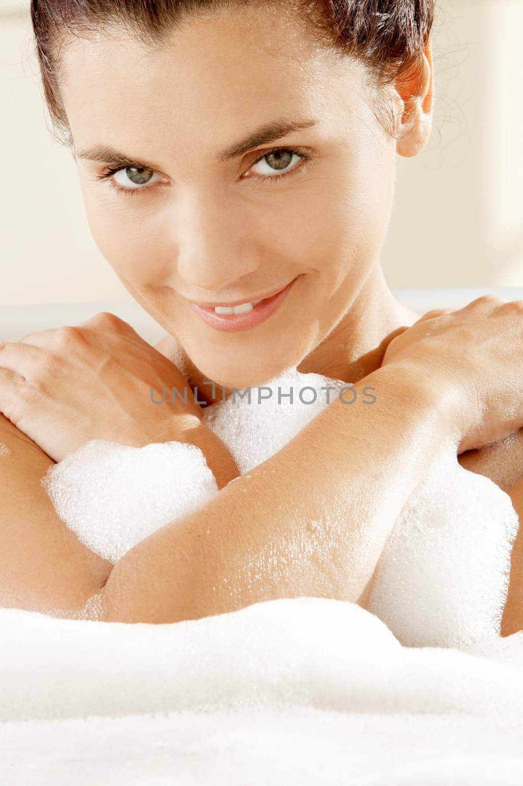 Portrait of a young woman smiling in a bathtub