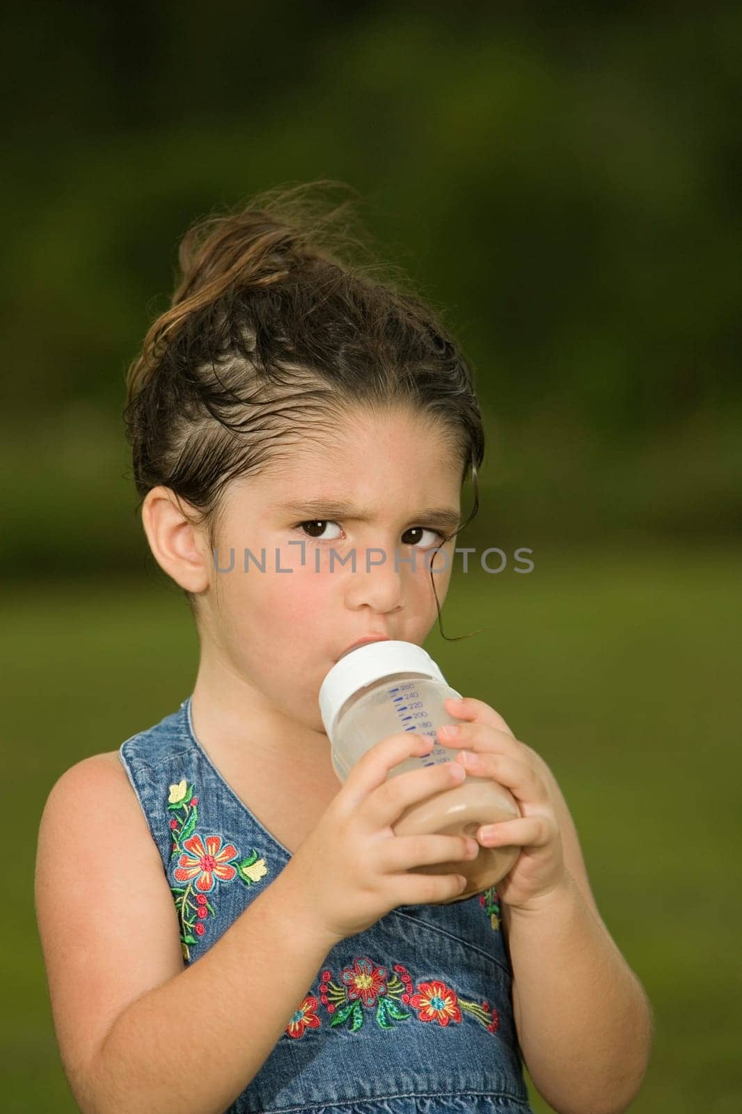 Portrait of a girl holding a baby bottle