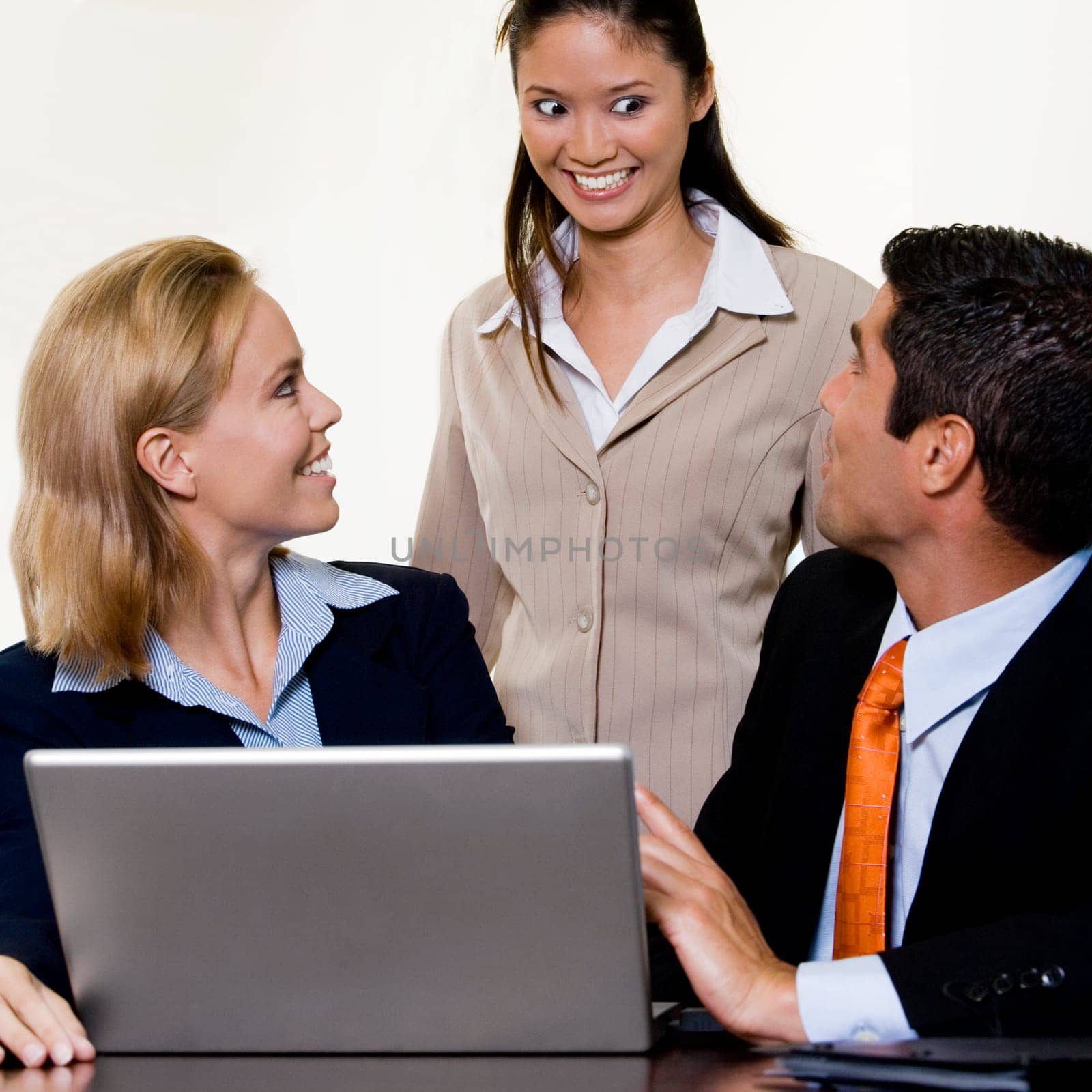 Businessman and two businesswomen in front of a laptop
