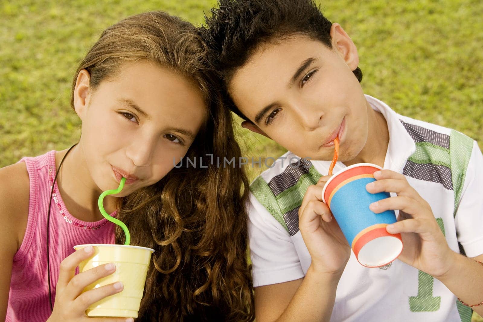 Portrait of a brother and sister drinking with straws