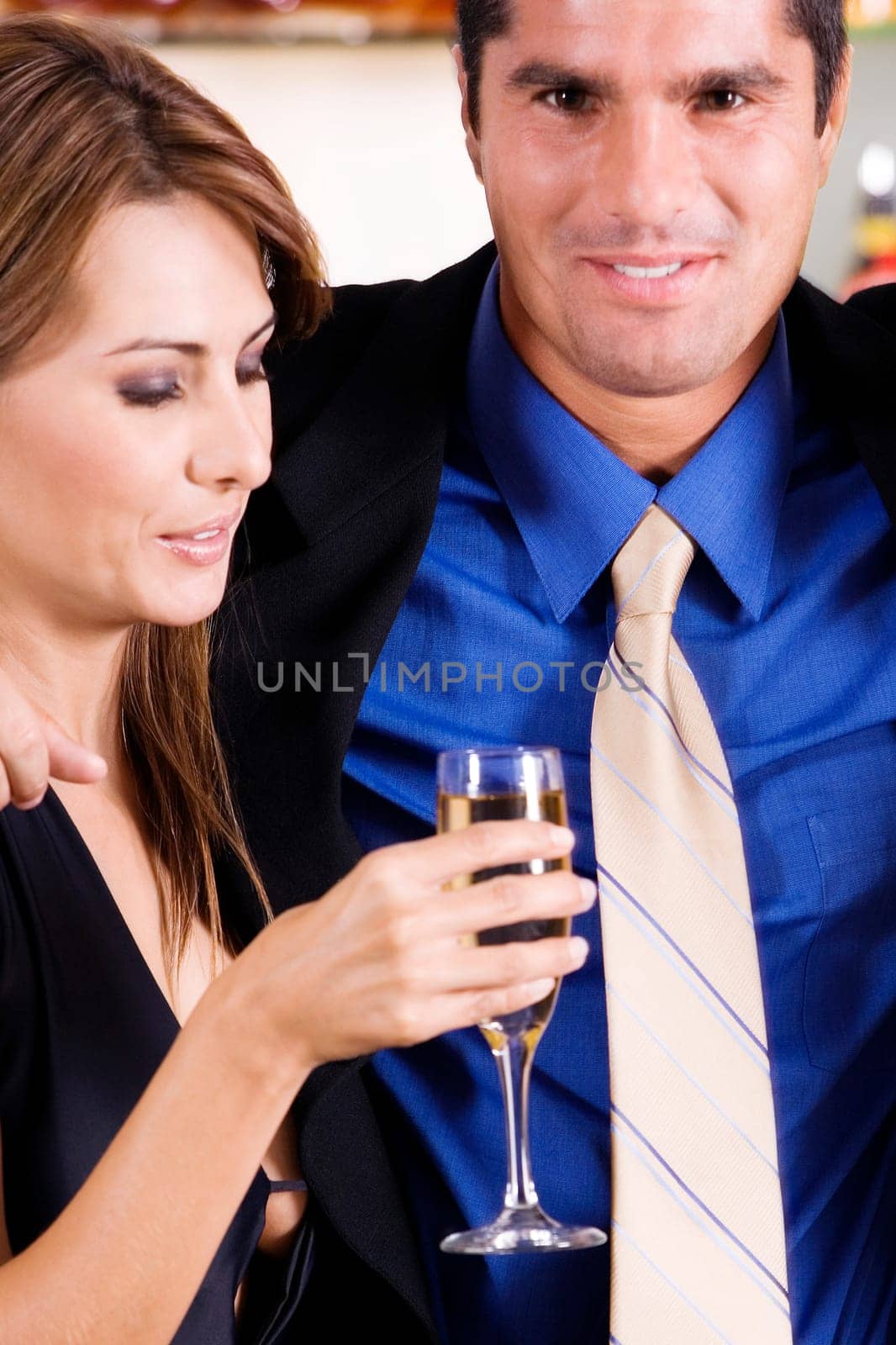 Side profile of a mid adult woman holding a glass of champagne with a mid adult man beside her