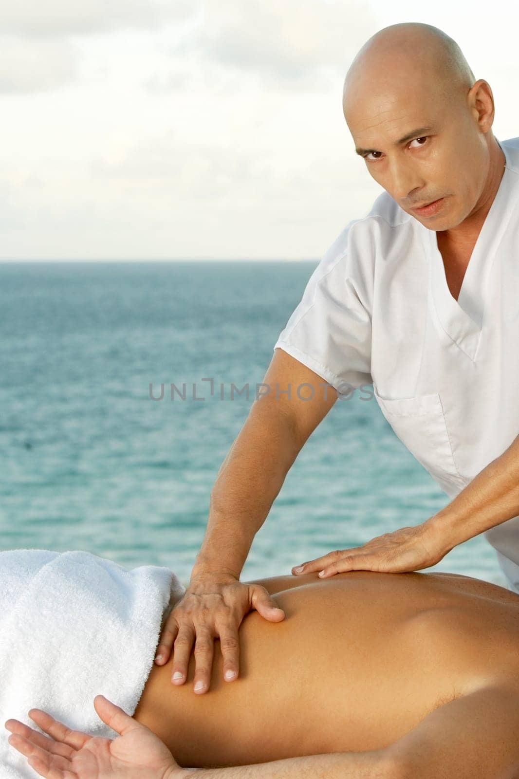 Portrait of a mature man giving a man a back massage