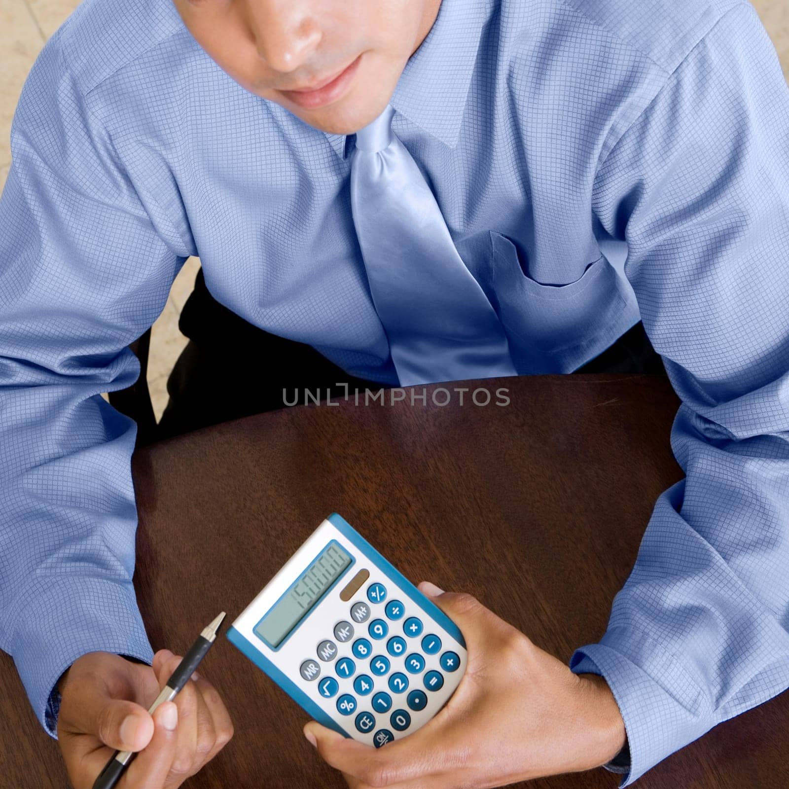 High angle view of a businessman holding a calculator and a pen