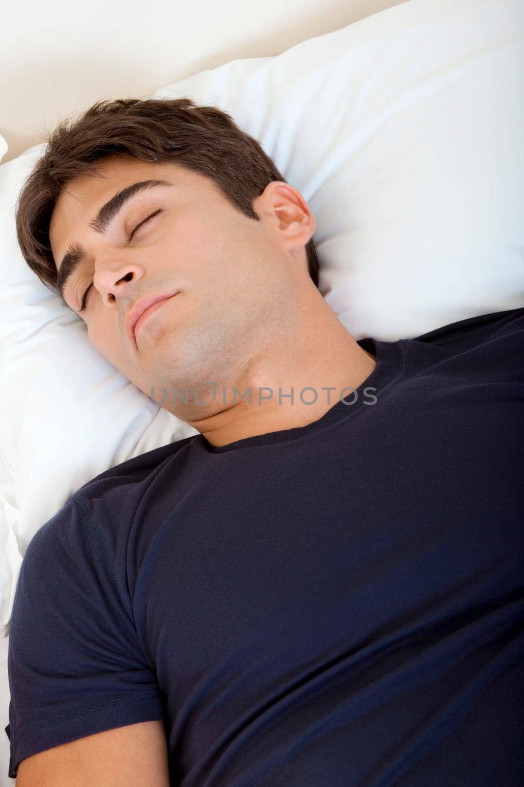 High angle view of a young man sleeping on a bed