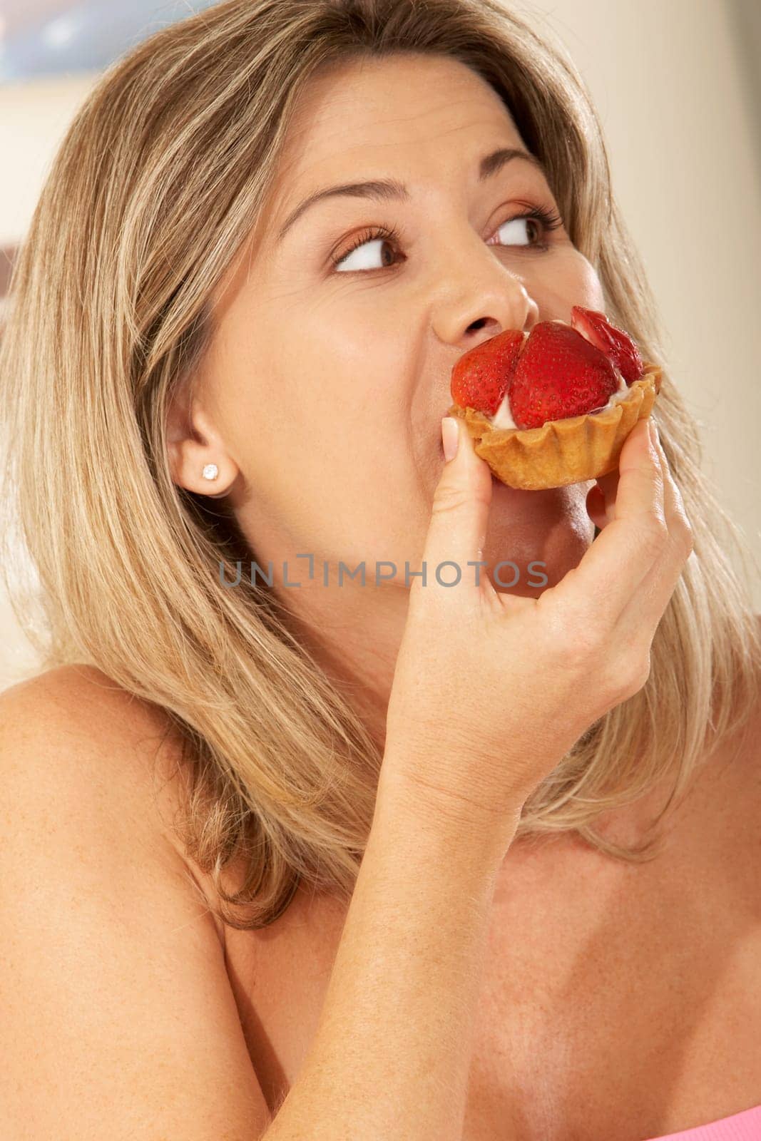 Close-up of a mid adult woman eating a strawberry tart