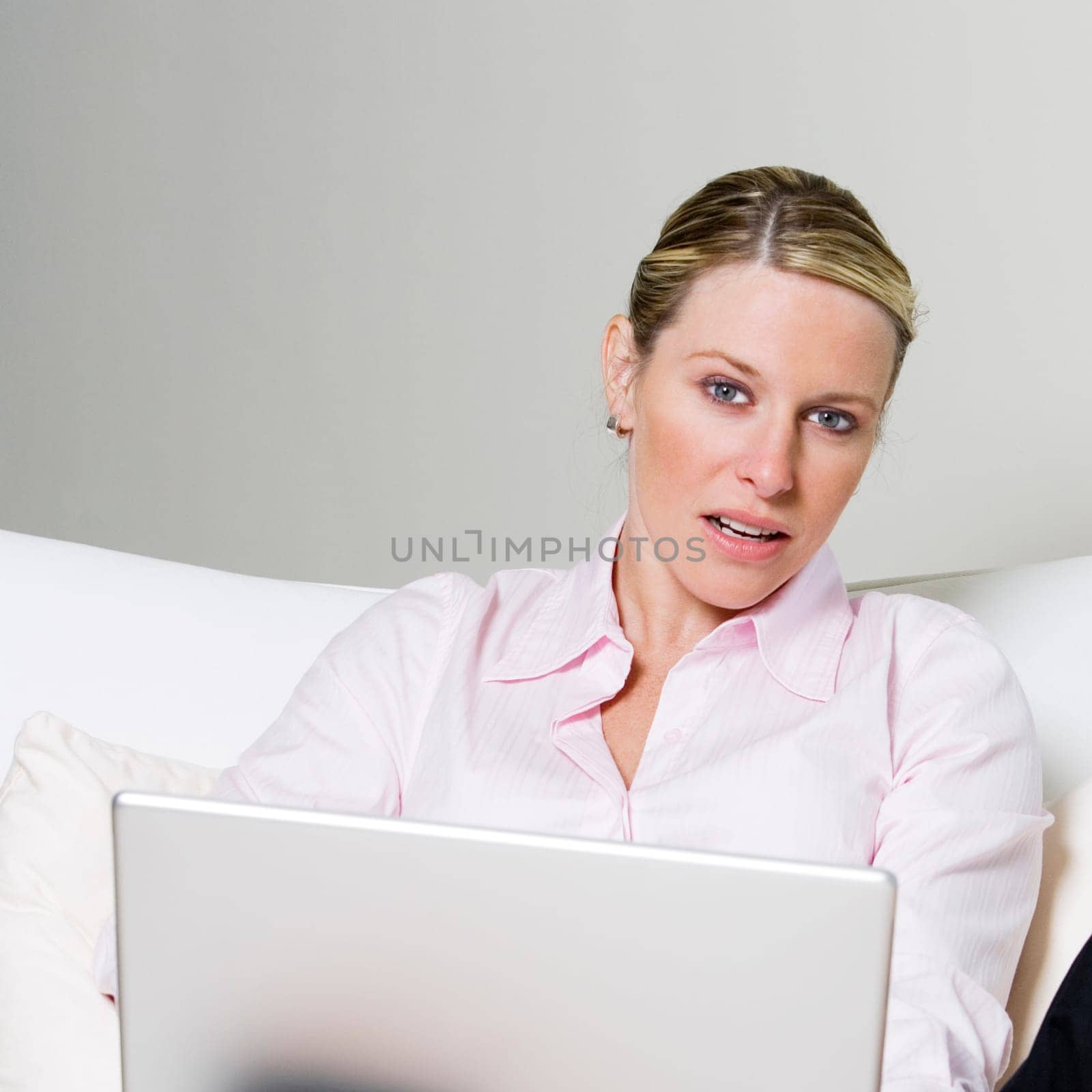 Portrait of a businesswoman sitting on the bed holding a laptop