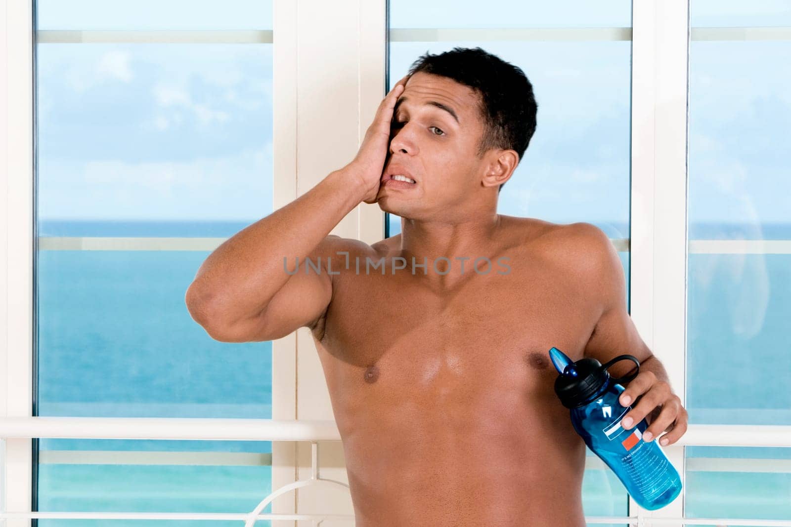 Close-up of a young man holding a bottle of water