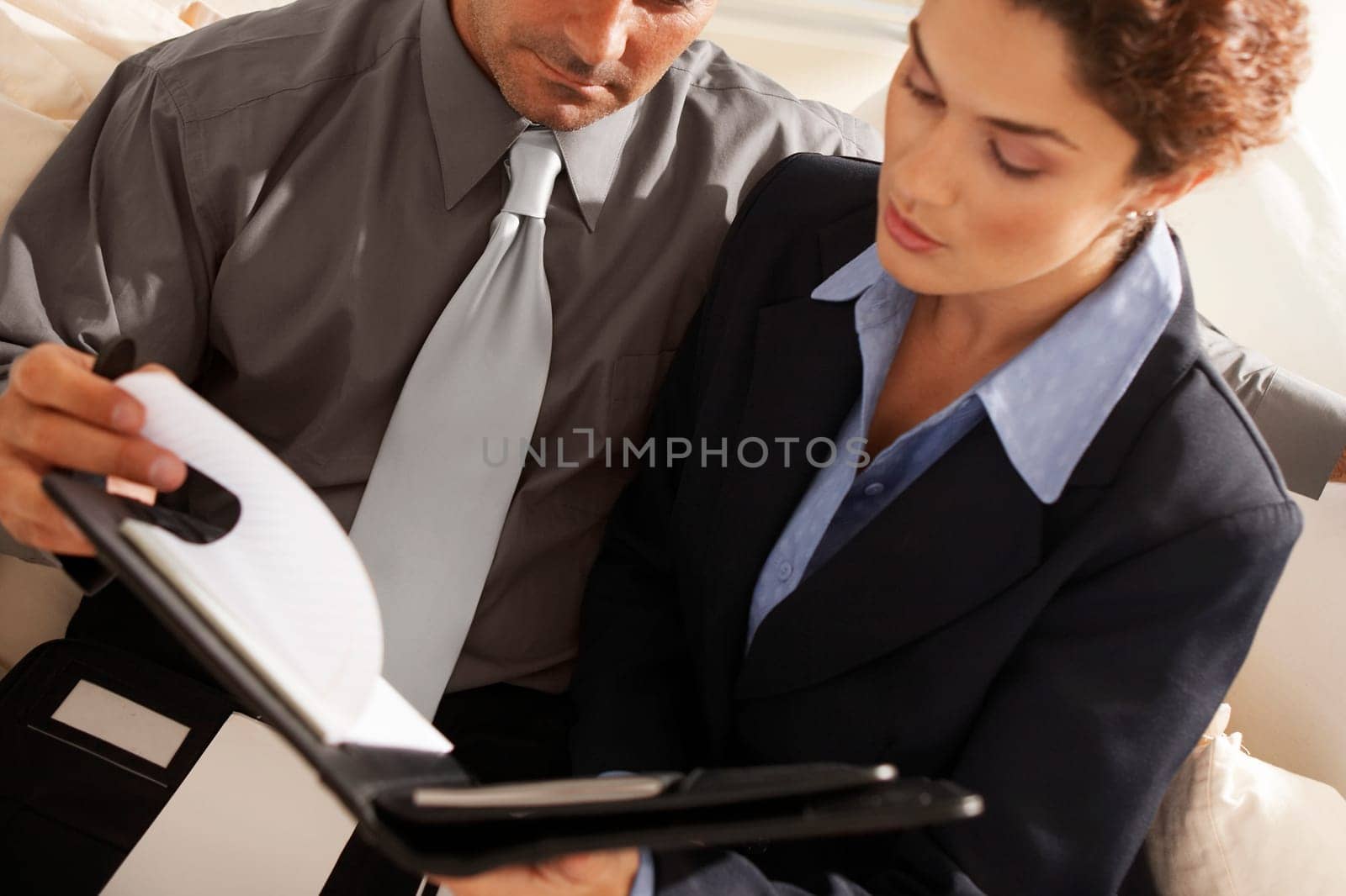 Close-up of a businesswoman with a businessman holding a file