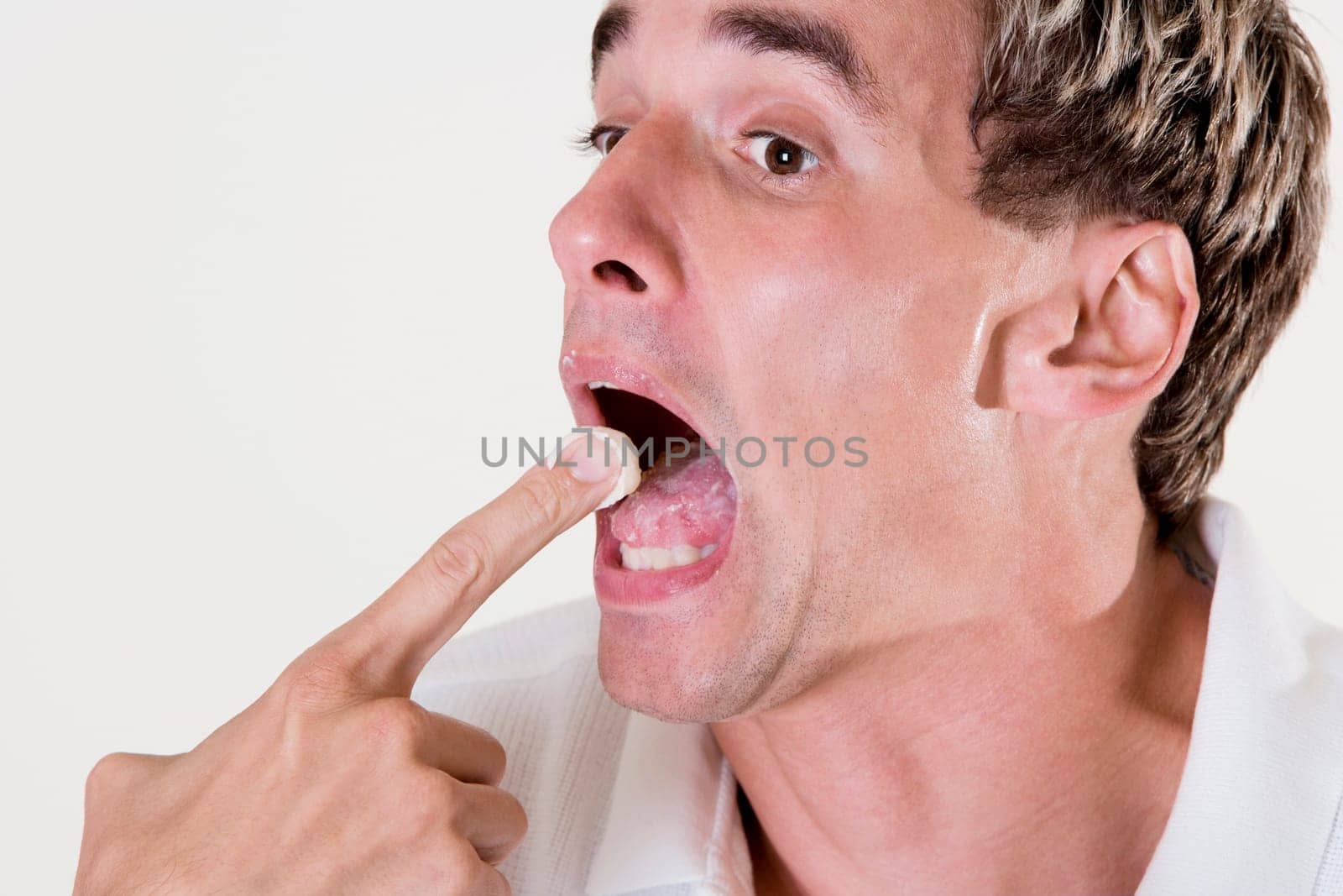Side profile of a mid adult man eating a fruit tart