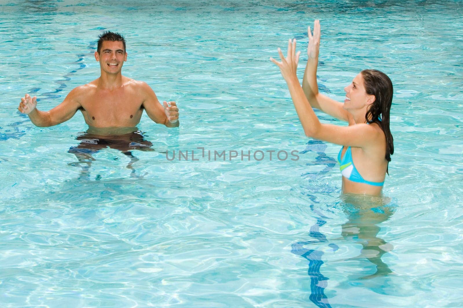 Young couple playing in a swimming pool