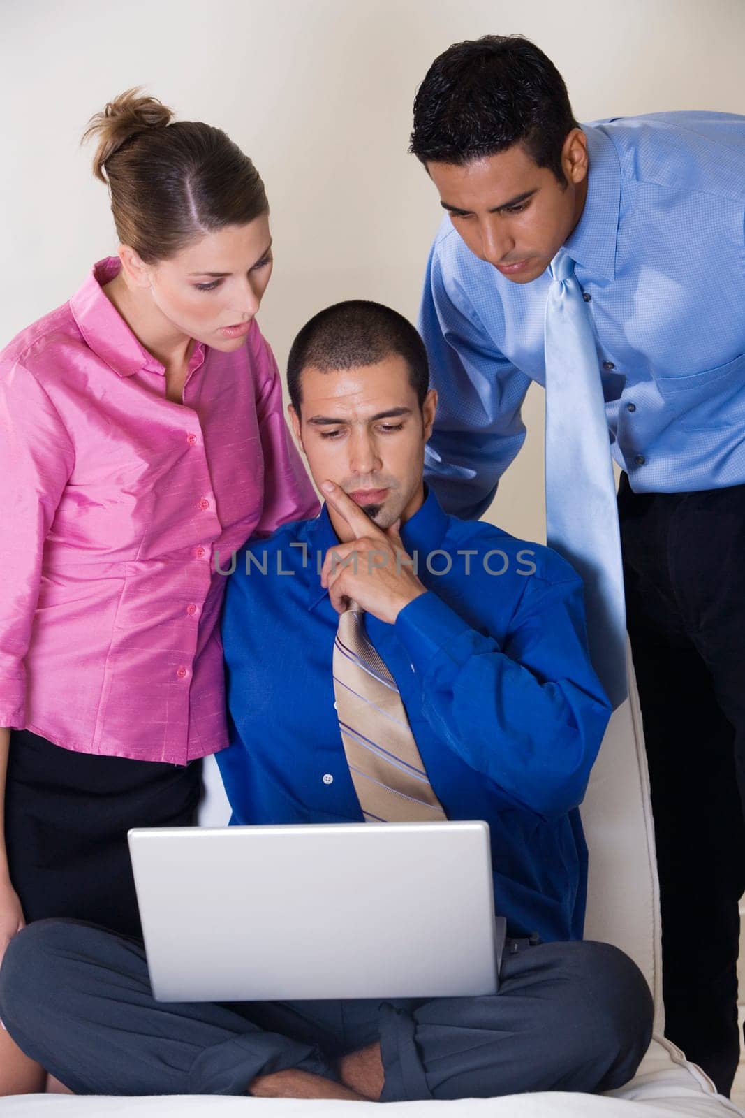 Two businessmen and a businesswoman in front of a laptop