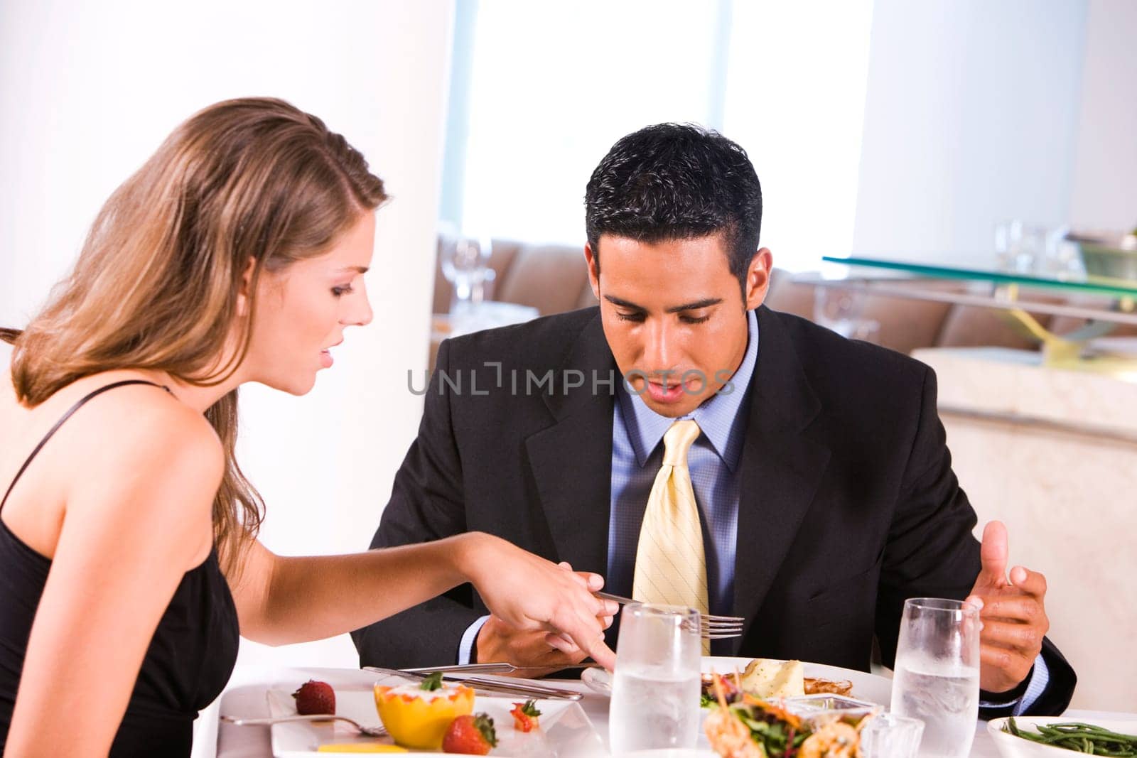 Side profile of a young woman and a mid adult man eating in a restaurant