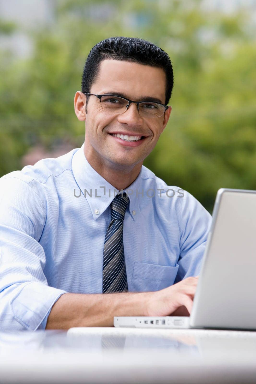 Portrait of a businessman using a laptop at a sidewalk cafe