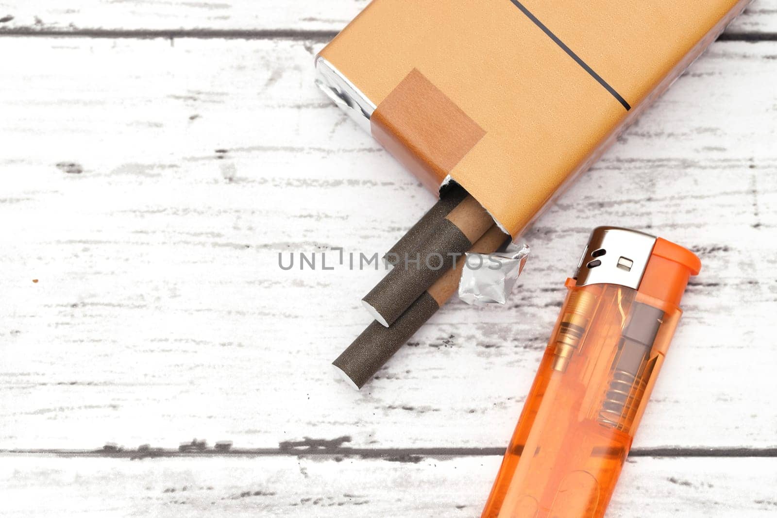 cigarette with lighter on a white grunge wooden table