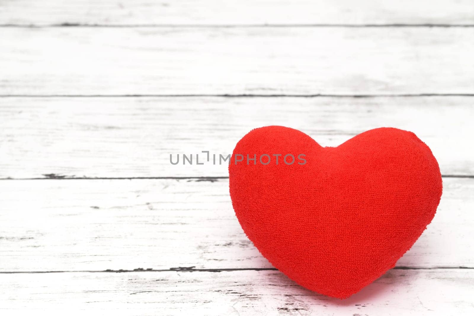 Red heart decoration on an aged white wooden background