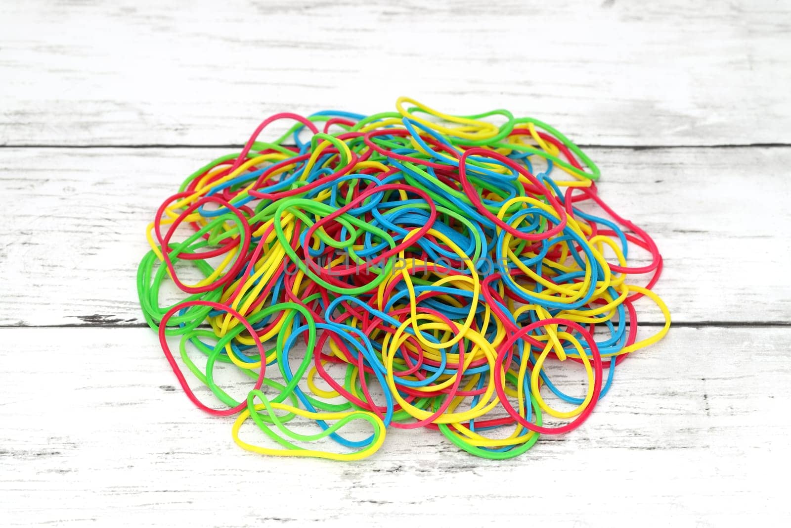 Colorful rubber bands on a white wooden table　