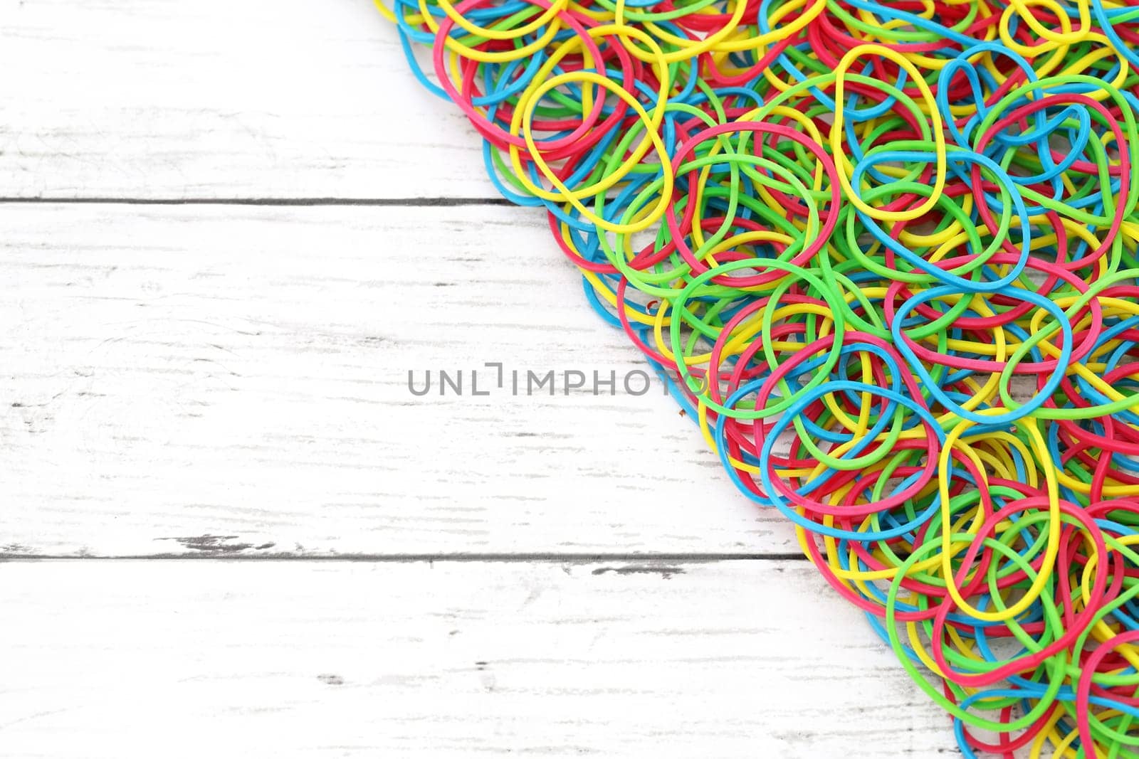 Colorful rubber bands on a white wooden table　
