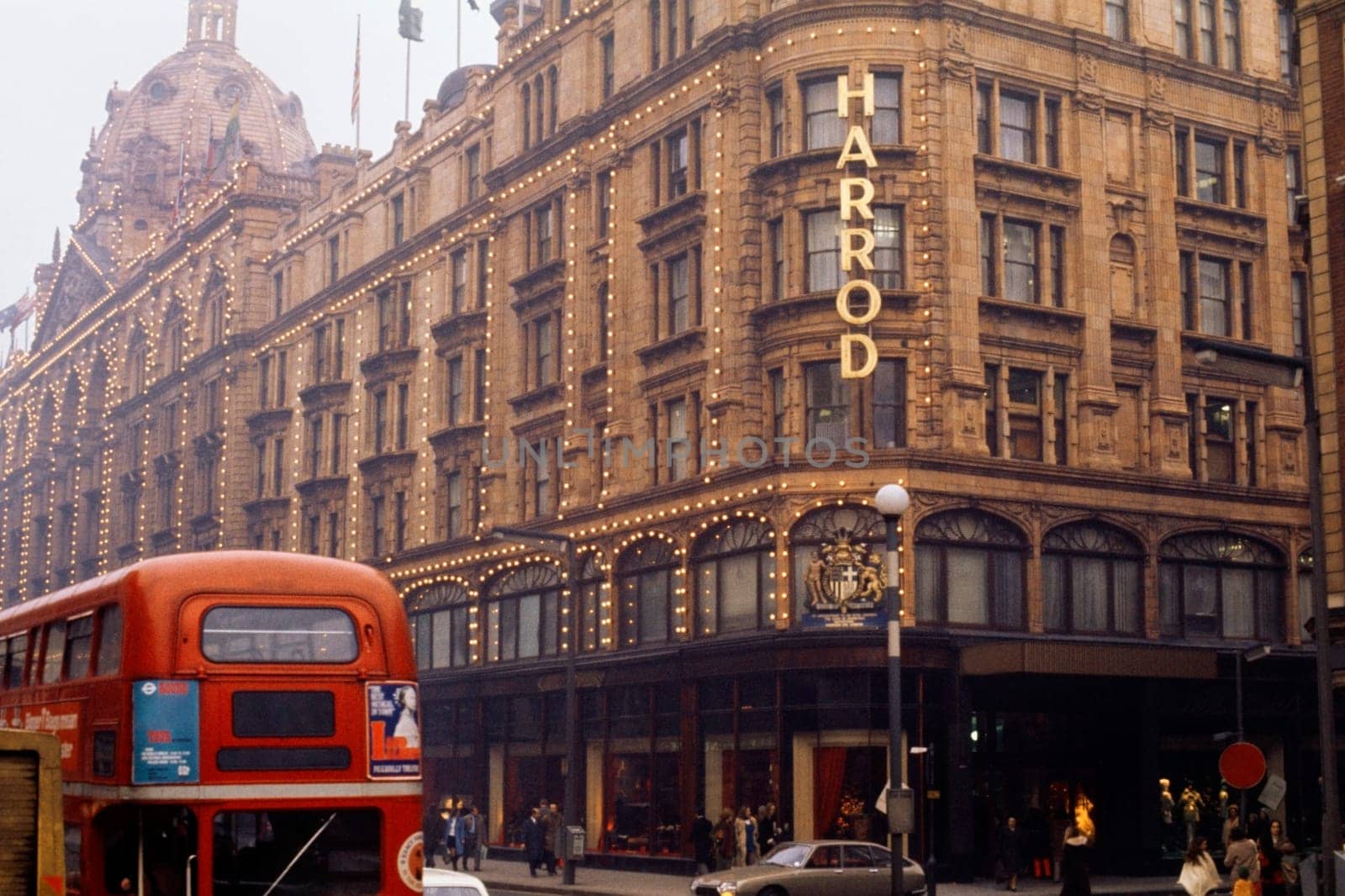 View of Harrods with a red bus seen passing by, London, England