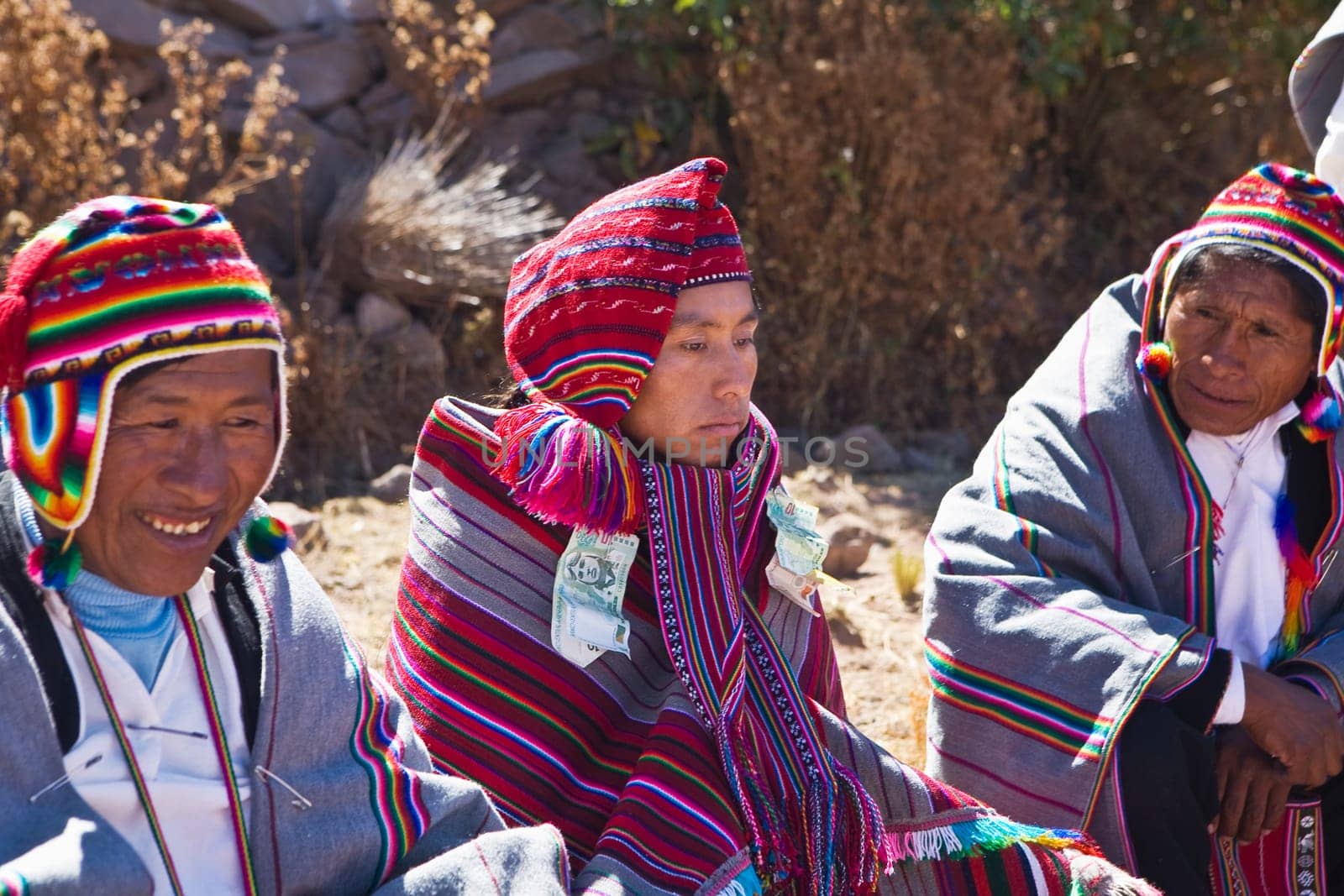 Mature man and a young man sitting with a groom, Taquile Island, Lake Titicaca, Puno, Peru