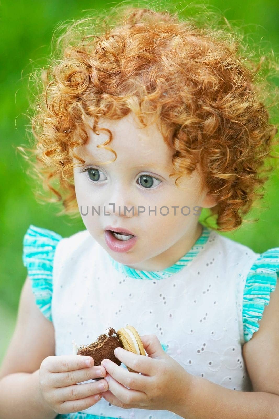 Close_up of a girl holding a biscuit