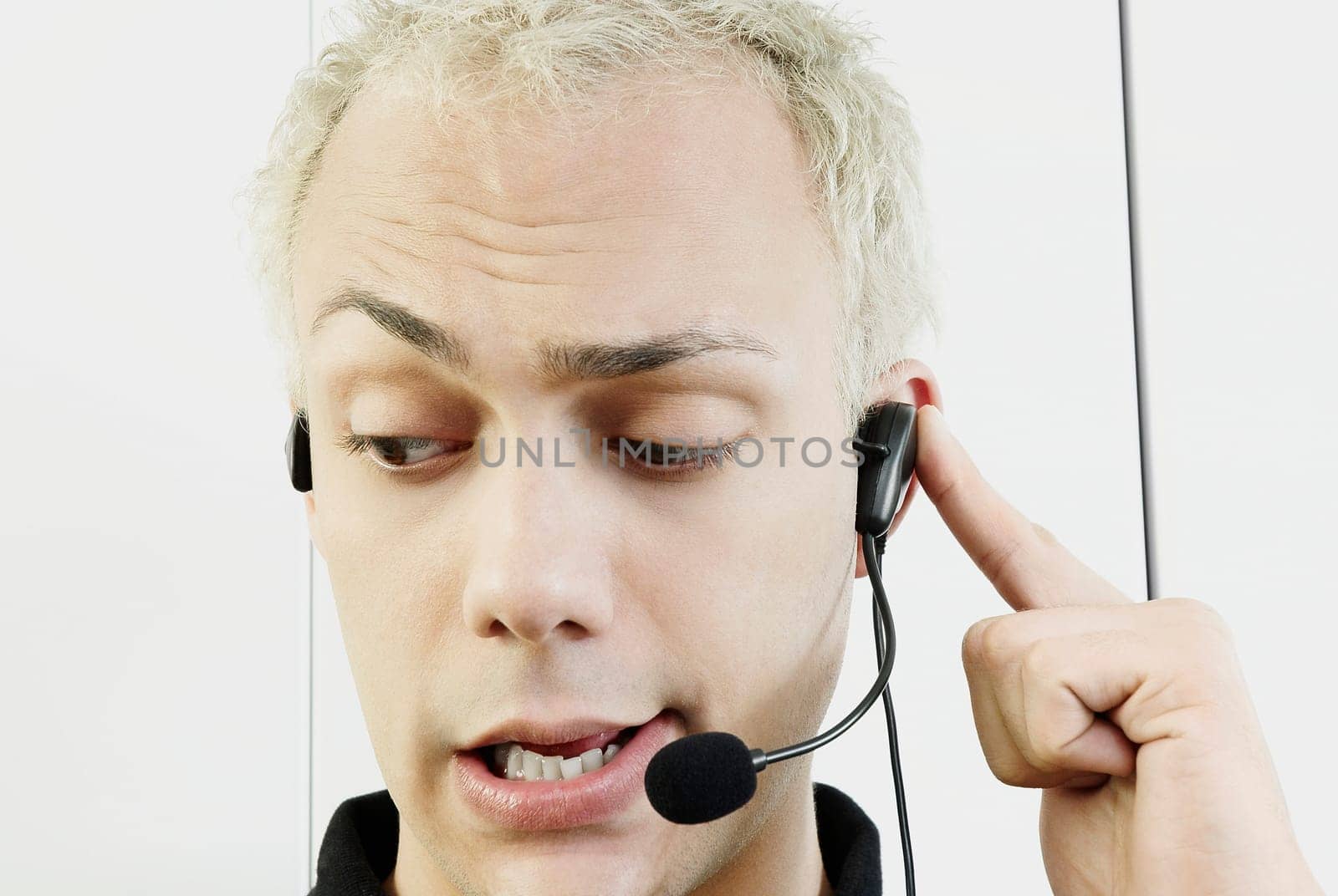 Close_up of a young man wearing headset and talking