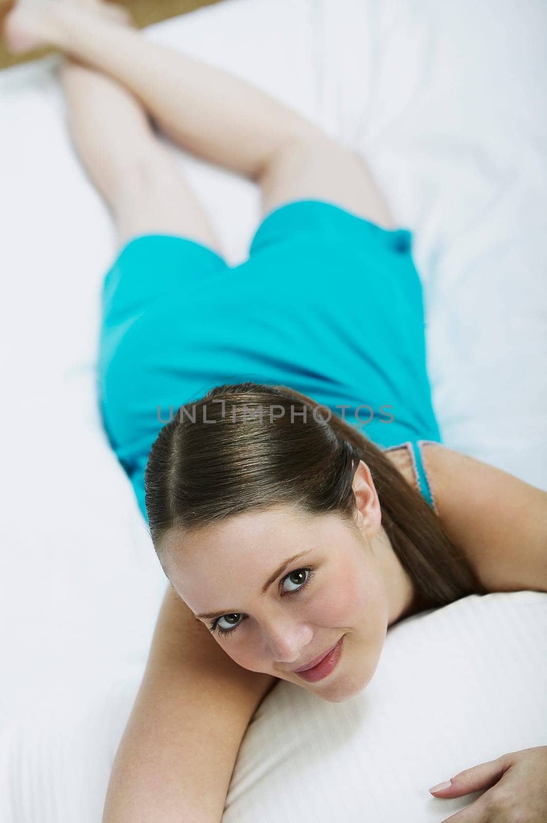Portrait of a young woman lying on the bed