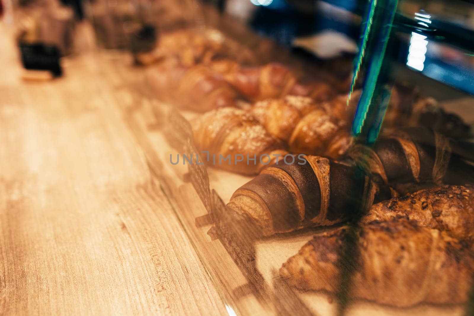 The waiter pulls out croissants in a cafe window. Blurred background. High quality photo