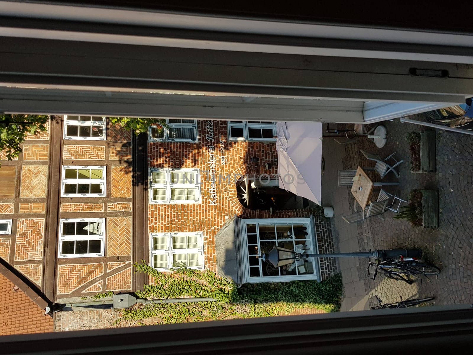 LÜNEBURG, NIEDERSACHSEN, GERMANY - JULI 27, 2018:..View from a hotel window onto a small market square and a coffee roasting plant in Lüneburg.