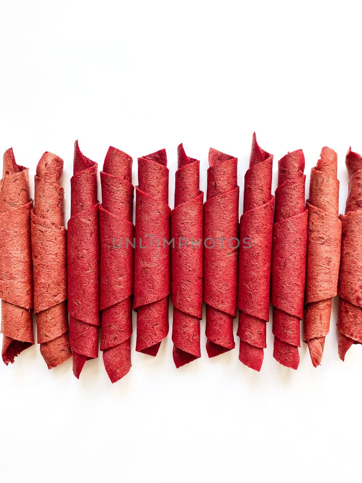 Red fruit leather rolls isolated on white. Fruit candy - pastille. Top view