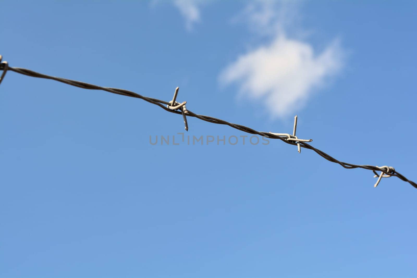 Barbed wire on the fence in front of a private property