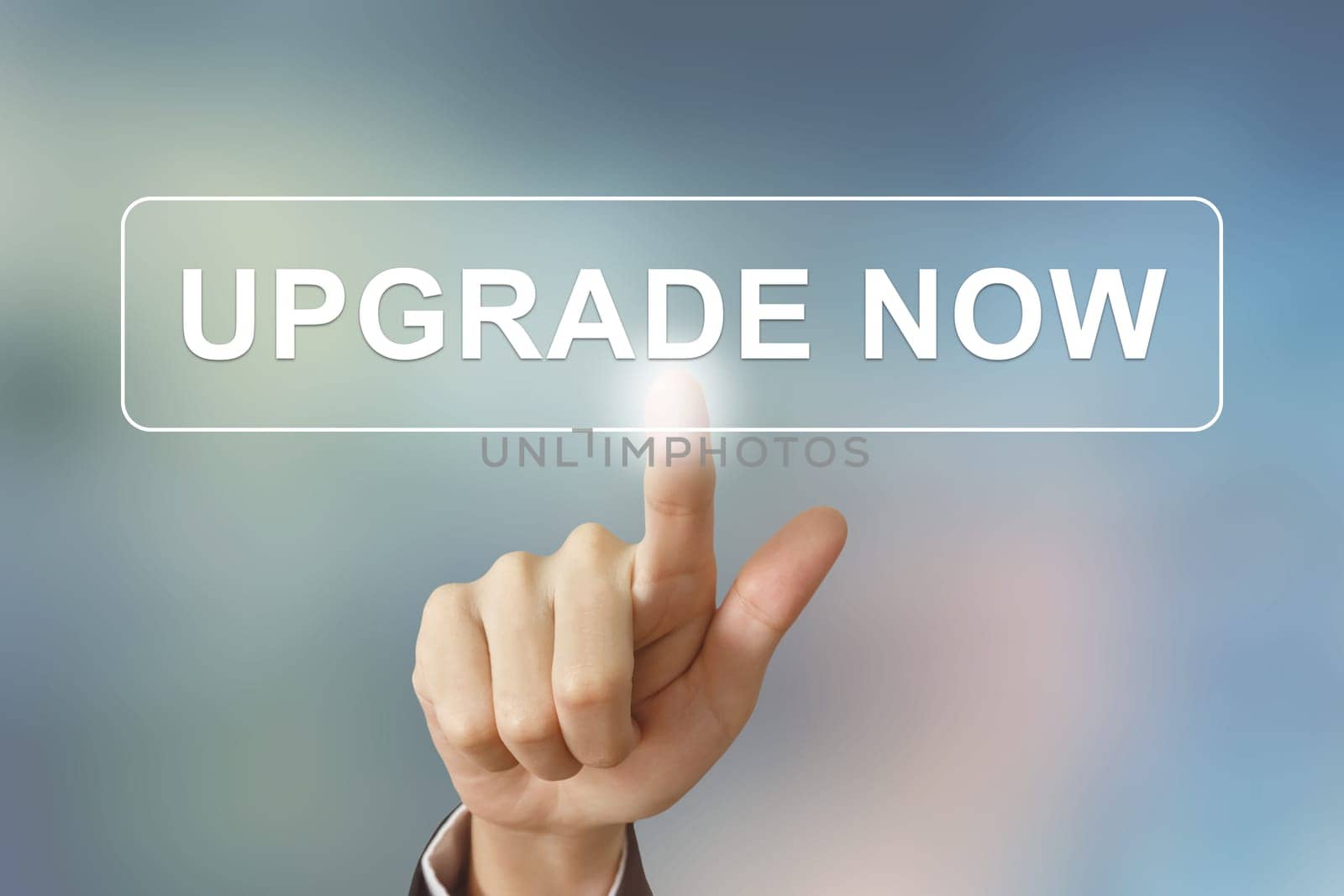 business hand pushing upgrade now button on blurred background