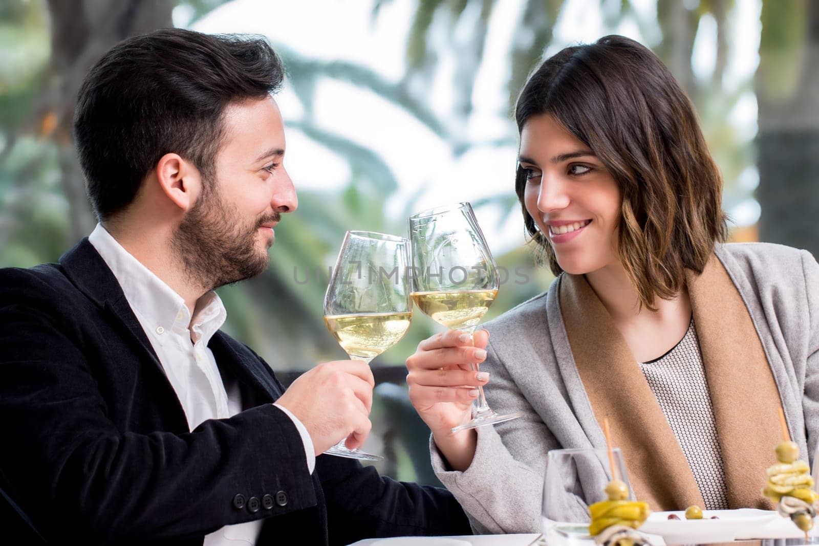 Close up of young handsome Couple sharing special moment white wine in restaurant.